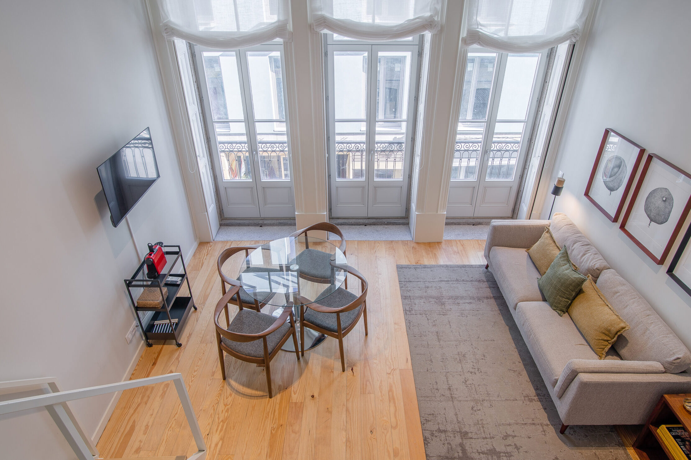 Bright living area with tall windows at North Living Apartments in Porto.